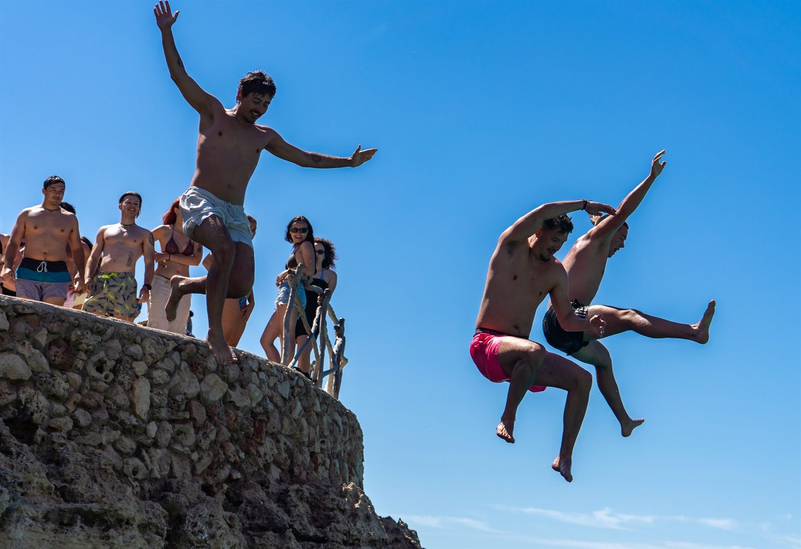 Participantes de The Tribe saltando al mar en Menorca durante un intercambio Erasmus+ de Maditerránea